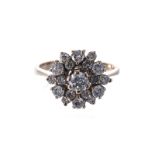 A DIAMOND CLUSTER RING centred with a round brilliant-cut diamond weighing approximately 0.28cts,