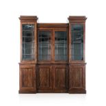 A FLAME MAHOGANY BREAKFRONT BOOKCASE, 19TH CENTURY in two parts, the outswept cornice above four