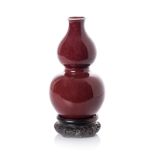 A CHINESE SANG-DE BOUEF DOUBLE GOURD VASE glazed overall with a deep red glaze, repair, crazing 21cm