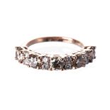 A DIAMOND HALF-ETERNITY RING claw-set to the centre with eight cognac-coloured round brilliant-cut