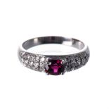 A RUBY AND DIAMOND RING centred with an oval mixed-cut ruby weighing approximately 0.80cts, the band