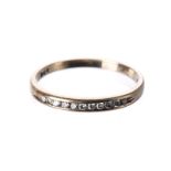 A DIAMOND HALF-ETERNITY RING channel-set to the centre with eleven round brilliant-cut diamonds