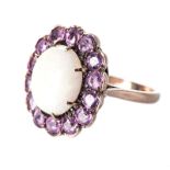 AN OPAL AND PINK SAPPHIRE RING Centred with an oval cabochon opal, within a conforming surround of