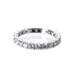 A DIAMOND ETERNITY RING claw set throughout with round brilliant-cut diamonds weighing approximately