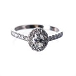 A DIAMOND RING centred with a claw-set oval-cut diamond weighing approximately 0.40cts, the