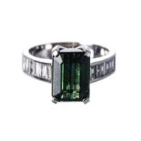 A GREEN TOURMALINE AND DIAMOND RING centered with a claw-set emerald-cut green tourmaline weighing