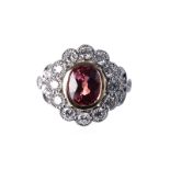 A PADPARADSCHA SAPPHIRE AND DIAMOND RING centred with an oval mixed-cut Padparadscha sapphire