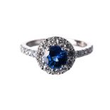 A SAPPHIRE AND DIAMOND RING centred with a circular mixed-cut sapphire weighing 1.207cts, the