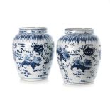 A PAIR OF CHINESE BLUE AND WHITE URNS each tapering ovoid body painted throughout depicting Fu-dog