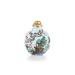 A CHINESE FAMILLE ROSE SNUFF BOTTLE depicting bamboo, blossoms and birds against a pale blue ground,