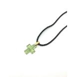 Lalique pale green carved cross, measuring approximately 21.5 x 17.5mm excluding bail, on a black