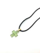 Lalique pale green carved cross, measuring approximately 21.5 x 17.5mm excluding bail, on a black