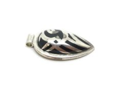 A silver pendant with a black stone set within the setting of the pendant