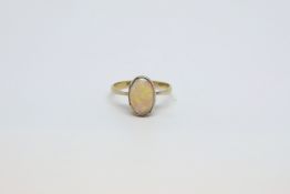 Opal ring, cabochon opal measuring approximately 11.5 x 7.9mm, rubover set in a yellow gold mount,