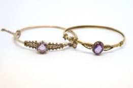 Two antique amethyst bangles, oval and hexagonal cut amethysts in decorative mounts, tested as 9ct