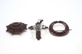 A collection of foil backed garnet/red stone jewellery including two brooches and a cross