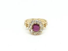 Ruby and diamond cluster ring, central oval cut ruby weighing an estimated 0.90ct, surrounded by old