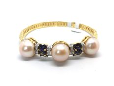 Pearl, diamond and polite bangle, three 13/14mm pinkish button pearls spaced by isolates and