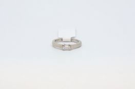 An 18ct white gold ring set with an emerald cut diamond. Size H