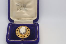 A boxed cameo brooch. The Shell cameo in a yellow metal mount believed to depict Dionysus. Stamped