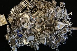 A quantity of mostly vintage silver charm bracelets and charms, weighing approximately 594g gross
