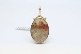 Stone set pendant, oval shaped pendant with a different hardstone set to each side