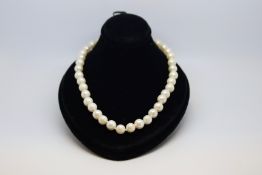 Single row pearl necklace, 7-8mm cultured pearls, strung knotted with a 9ct yellow gold clasp,