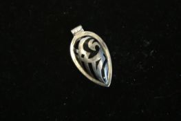 A silver pendant with a black stone set within the setting of the pendant