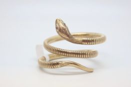 9ct yellow gold snake bangle, carved snake head set with garnet eyes, on a flexible coiled bangle,