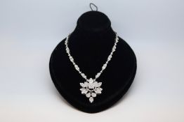 Diamond cluster necklace, diamond set floral cluster drop, on an integrated diamond set chain,