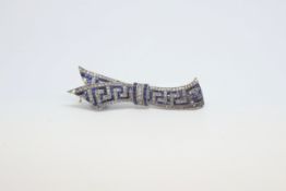 An early twentieth century sapphire and diamond ribbon bow brooch. Stamped 750 on the pin. 59mm in