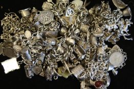 A quantity of mostly vintage silver charm bracelets and charms, weighing approximately 538g gross