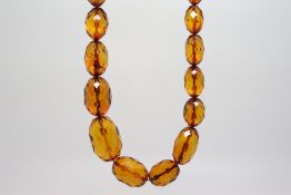 Faceted amber coloured bead necklace, graduated beads from 8mm in width to 27mm, gross weight