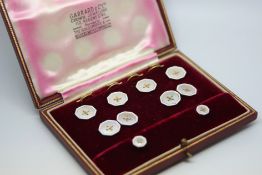 A boxed set of gold and enamel dress studs, cufflinks and buttons. In a fitted Garrard and Co box.