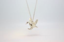 A silver flying duck pendant and chain.