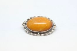 A butterscotch amber brooch. Stamped WMF 830 to the reverse