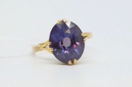 Single stone ring, oval cut synthetic colour change sapphire, claw set in yellow metal tested as