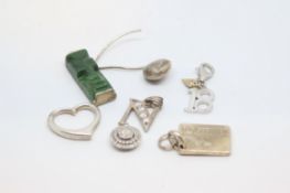 A quantity of mainly silver pendants/charms including an open heart and an '18', approximately 22g