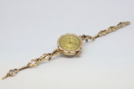Lady's scalloped circular Art Deco 9ct gold wristwatch on integral fine scroll design sprung