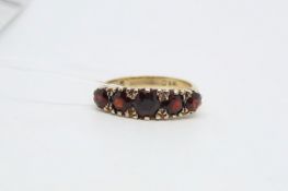Victorian five stone garnet ring, graduating round cut garnets with carved detail to the half