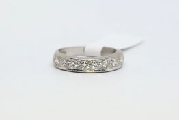 A half diamond eternity ring in white metal. Stamped 18ct. Approx 0.48cts total weight. Size K.
