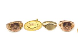 9ct yellow gold medallion, three 9ct gold signet rings and a 22ct gold wedding band, gross weight
