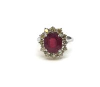 Ruby and diamond cluster ring, oval cut ruby measuring 9.6 x 8.6mm, surrounded by round brilliant