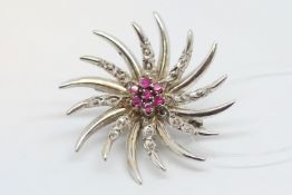 Ruby spray brooch, central cluster of seven round cut rubies with rays of white metal stamp 18ct