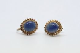 Single stone gem-set earrings, oval cabochon cut blue stone in an ornate setting, mounted in 9ct