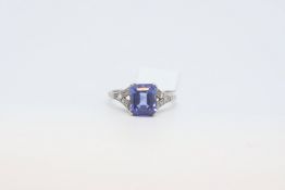 A blue gemstone in a white metal mount with old cut diamond set shoulders. Size K
