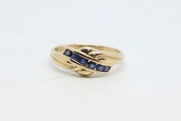 Six stone sapphire ring, diagonally set with six round cut sapphires, in a channel setting, above