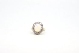 Opal and diamond cluster ring, 11x9mm oval cabochon cut opal claw set, a cluster of diamonds