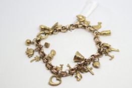 9ct yellow gold charm bracelet including heart, dolphins, key, dice and an elephant, weighing