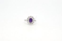 Amethyst and diamond cluster ring, central oval cut amethyst measuring 7.10 x 4.90mm, surrounded